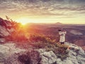 Landscape photograper with hand on camera and tripod