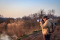 Landscape photographer with camera and telephoto lens photographing wildlife Royalty Free Stock Photo