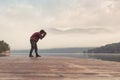 Landscape photographer at lake pier in misty morning