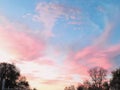 Landscape photography beautiful autumn sky at sunset with layered clouds on a turquoise sky reflecting the sunset pink sun and