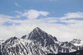 Snow top mountain peak with cloudy blue skies Royalty Free Stock Photo