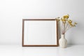 Landscape picture frame mockup in white minimalistic interior with dry flowers decor Royalty Free Stock Photo