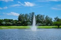 Landscape pond with a fountain and wide green lawns