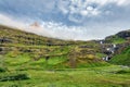 Landscape of pyramid shaped volcanic mountain and Klifbrekkufossar waterfall in Mjoifjordur fjord on summer at Iceland Royalty Free Stock Photo