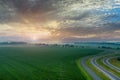 Landscape after rain with a light haze sunrise dawn a field with green grass summer near road Royalty Free Stock Photo