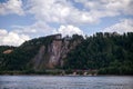 The red house stands on top of a cliff, a train is going below. Royalty Free Stock Photo