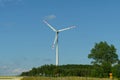 Landscape from renewable energy wind turbine with field, forest and sky Royalty Free Stock Photo
