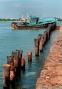 A landscape of the river arasalaru with abandoned old boat and palm tree stem fence near karaikal beach. Royalty Free Stock Photo