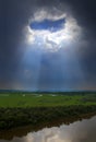 Landscape with river and hole in dark clouds