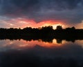 The landscape of the river after the storm during the summer evening at sunset, the reflection in the water, the dark dramatic Royalty Free Stock Photo