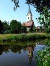 Village church is reflected in the river