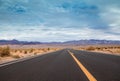 landscape with a road crossing the desert of death valley in California with the mountains in the background Royalty Free Stock Photo