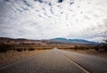 landscape with a road crossing the desert of death valley in California with the mountains in the background Royalty Free Stock Photo