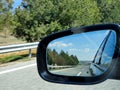Landscape and road reflection in car rearview black mirror. Royalty Free Stock Photo