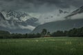 Landscape of Romsdalen with mountains of Troll Wall in rain clouds and red cabin in Norway Royalty Free Stock Photo