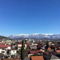 Landscape. The roofs of houses against the blue sky and snowy mountains on the horizon. Royalty Free Stock Photo