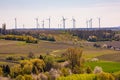 Landscape of a rural region with fields and trees in front of a large number of wind turbines Royalty Free Stock Photo
