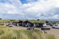 Landscape sand dunes covered with bushes and grass and a traditional Scandinavian house with a moss-covered roof. Royalty Free Stock Photo