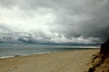 Landscape with sand and storm clouds over the ocean