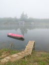 Landscape with Sava river fishing huts and moored boat near riverbank during misty autumn morning Royalty Free Stock Photo