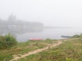 Landscape with Sava river fishing huts and moored boats along riverbank during misty autumn morning Royalty Free Stock Photo