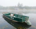 Landscape with Sava river and moored boat in water and fishing huts in fog during foggy autumn morning Royalty Free Stock Photo