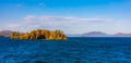 Landscape scene of  autumn trees in the middle of Lake George coast under a blue sky Royalty Free Stock Photo