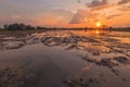 Landscape of sunrise sunset over a farm field after harvest. Sun breaks through clouds creating reflection in water standing Royalty Free Stock Photo