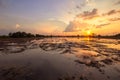 Landscape scene of sunrise sunset over a farm field after harvest. Sun breaks through clouds creating reflection in water standing Royalty Free Stock Photo