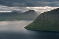 Landscape scenery of coastline and mountains on Faroe Islands with dramatic clouds in sky Royalty Free Stock Photo