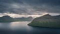 Landscape scenery of coastline and mountains on Faroe Islands with dramatic clouds in sky Royalty Free Stock Photo