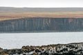 Landscape scenery of rocky basalt volcanic textured columns in Kalfshamarsvik in Iceland during rainy weather.