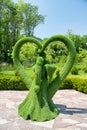 Landscape sculpture dedicated to wedding day - bride and groom stand in symbol of heart