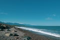 Beautiful seascape. Waves, rocky shore, mountains in the distance. Royalty Free Stock Photo