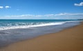 Landscape with sea, surf, sandy beach and high mountains at far Royalty Free Stock Photo