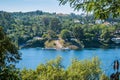 Blurred tree leaves overlooking the river ZÃÂªzere with the structure of the fluvial beach next to Cabril dam, PedrogÃÂ£o Grande PT Royalty Free Stock Photo