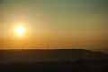 Landscape and several wind turbines silhouettes on sunset