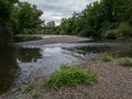 Landscape with shallow rapids of river Ukrina flows between gravel islands and riverbanks overgrown with green forest, natural Royalty Free Stock Photo