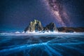 Landscape of Shamanka rock and milky way on sky with natural breaking ice in frozen water on Lake Baikal, Siberia, Russia Royalty Free Stock Photo