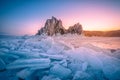 Landscape of Shamanka rock at sunrise with natural breaking ice in frozen water on Lake Baikal, Siberia, Russia