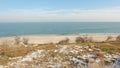 Landscape on the shore of the sea with snow and blue sky.