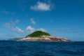 Landscape shot of beautiful island surrounded by vibrant blue reflected sea