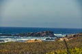 Landscape shot of a beautiful rocky coastline and undulating ocean in harmony with blue sky