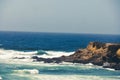 Landscape shot of a beautiful rocky coastline and undulating ocean in harmony with blue sky