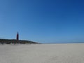 Landscape shot of the coast and the red Texel Lighthouse in De Cocksdorp, Netherlands Royalty Free Stock Photo
