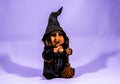 Landscape shot of a dwarf witch toy with a purple color in the background