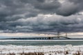 Landscape shot of the Mackinac Bridge under the dramatic cloudy sky in the winter time Royalty Free Stock Photo