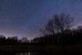 Landscape shot of the night sky in the forest with a lake in the forground Royalty Free Stock Photo