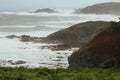 Landscape shot of the sea waves hitting rocks on the coast on a cloudy day Royalty Free Stock Photo