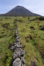 Landscape showing Ponta do Pico mount Pico, Portugal`s tallest mountain and volcano, with lavastone walls in the foreground Royalty Free Stock Photo